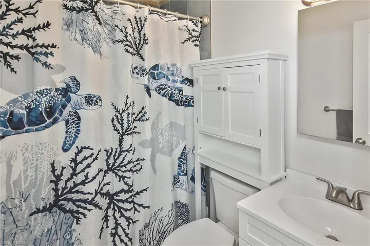 Full bath featuring curtained shower, vanity, and toilet