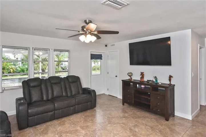 Living area featuring visible vents, baseboards, and a ceiling fan