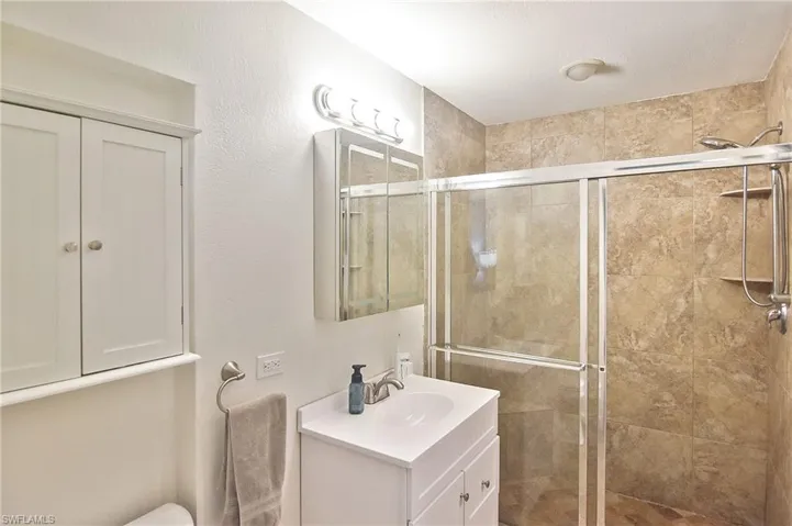 Bathroom with a stall shower and vanity