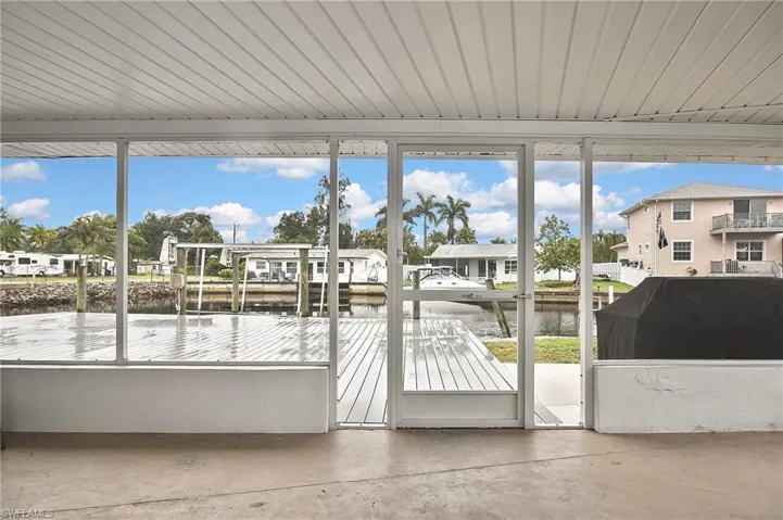 Unfurnished sunroom with a water view, a residential view, and a healthy amount of sunlight