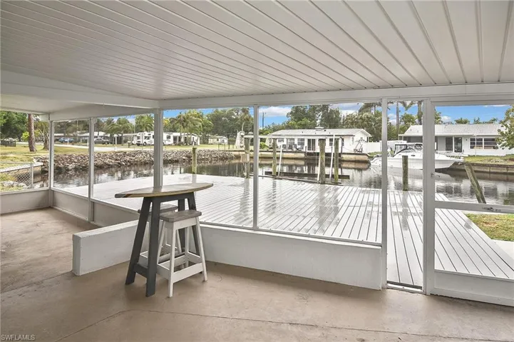 View of patio / terrace featuring a water view, a boat dock, and a residential view