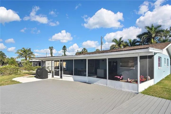 Rear view of property with a deck and a sunroom