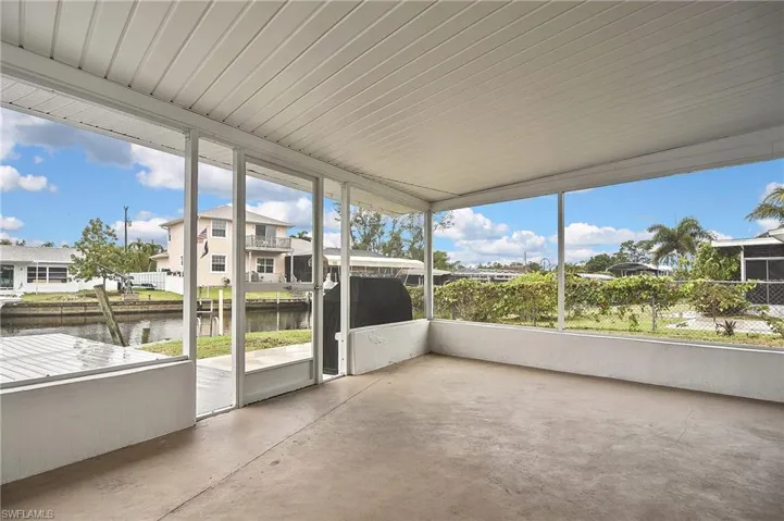 Unfurnished sunroom featuring a water view and a residential view