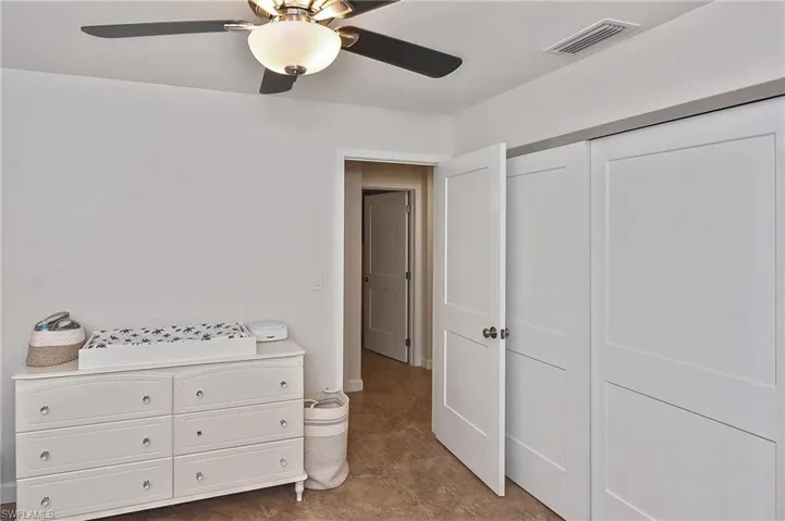 Bedroom with a closet, ceiling fan, and visible vents