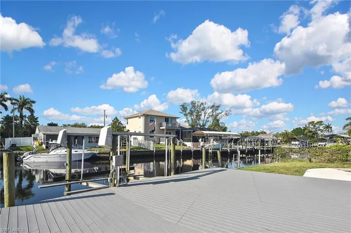 View of dock with a water view, a residential view, and boat lift