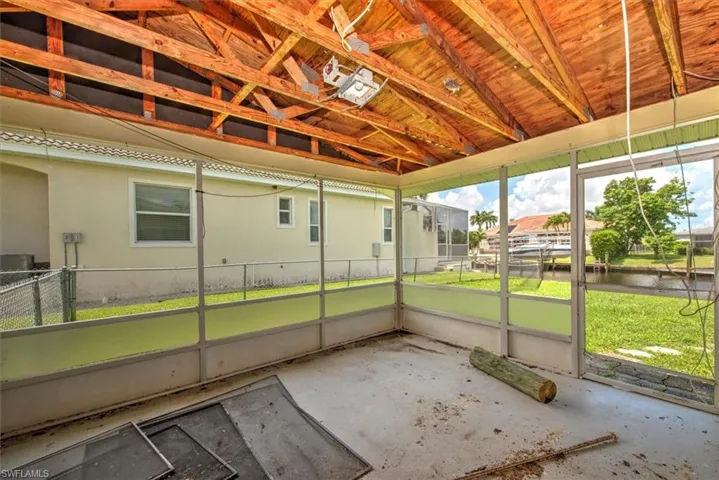 Unfurnished sunroom featuring lofted ceiling
