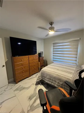 Bedroom featuring tile patterned flooring and ceiling fan