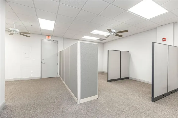 Hall featuring light carpet and a paneled ceiling