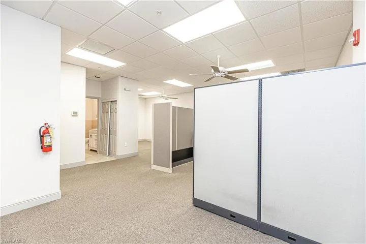 Carpeted spare room with a paneled ceiling and ceiling fan