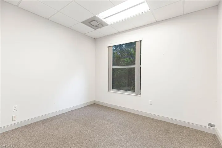 Carpeted empty room featuring a paneled ceiling