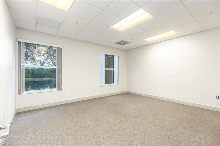 Unfurnished room featuring carpet floors and a drop ceiling