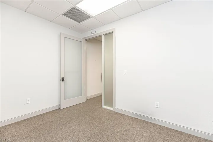 Spare room with a paneled ceiling and carpet floors