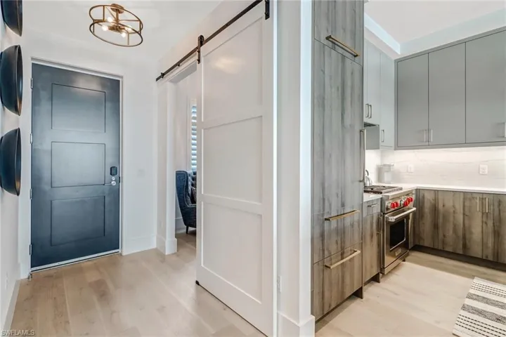 Kitchen with modern cabinets, light wood-style floors, designer stove, and a chandelier