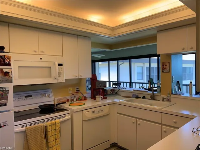 Kitchen featuring sink, crown molding, and white appliances