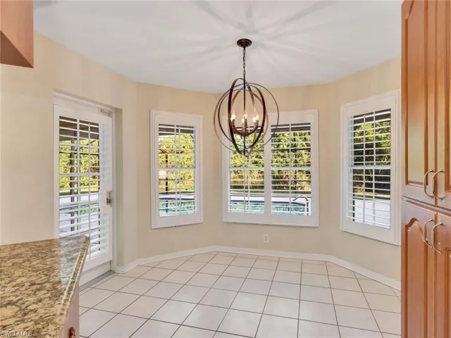 Unfurnished dining area featuring a chandelier and light tile patterned flooring