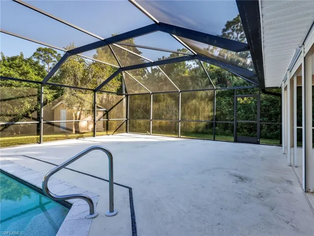 Swimming pool featuring a lanai, a sunroom, a patio, and an outdoor structure