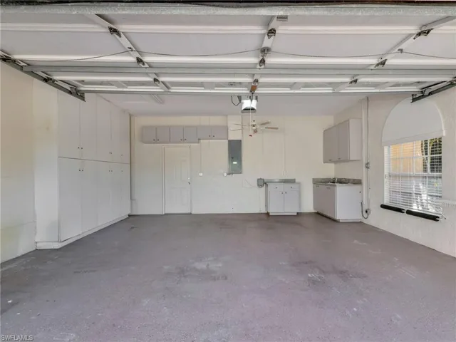 Garage featuring electric panel and a garage door opener