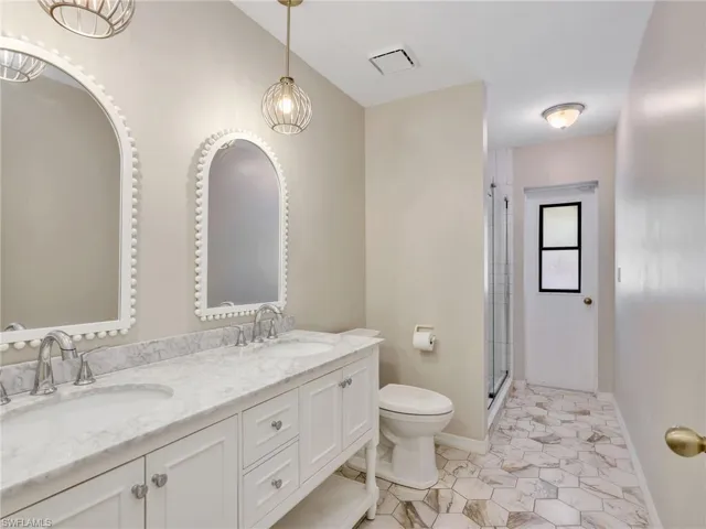 Bathroom featuring double vanity and a stall shower