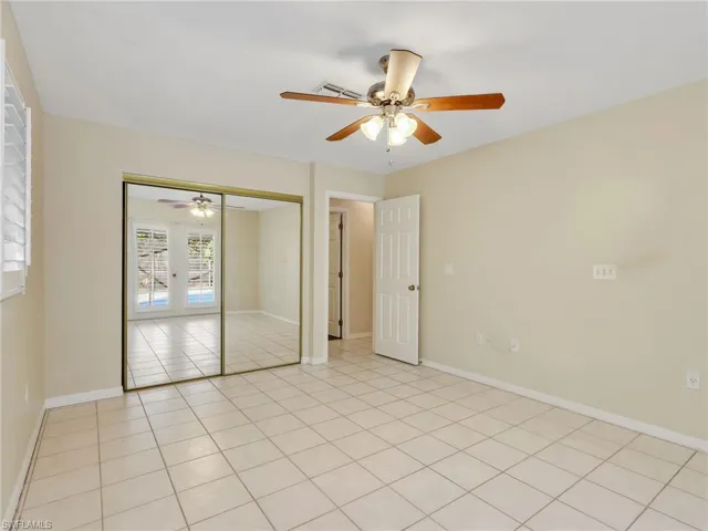 Unfurnished bedroom featuring ceiling fan, a closet, and light tile patterned floors