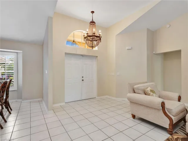 Entryway featuring a chandelier, light tile patterned floors, and a towering ceiling