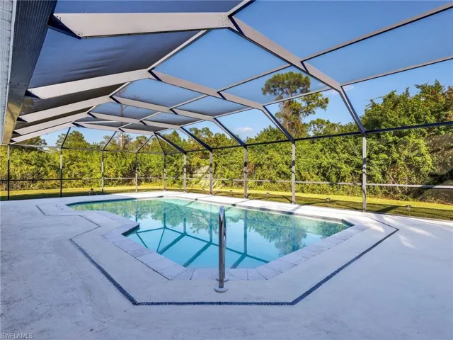 Swimming pool featuring glass enclosure and a sunroom