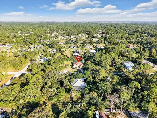 View of property location with a forest and nearby suburban area