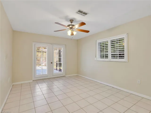 Empty bedroom featuring plenty of natural light, ceiling fan, french doors, and light tile patterned flooring