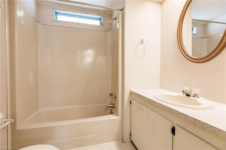 Full bathroom with toilet, vanity, shower / washtub combination, and tile floors