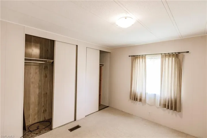 Unfurnished bedroom with light colored carpet