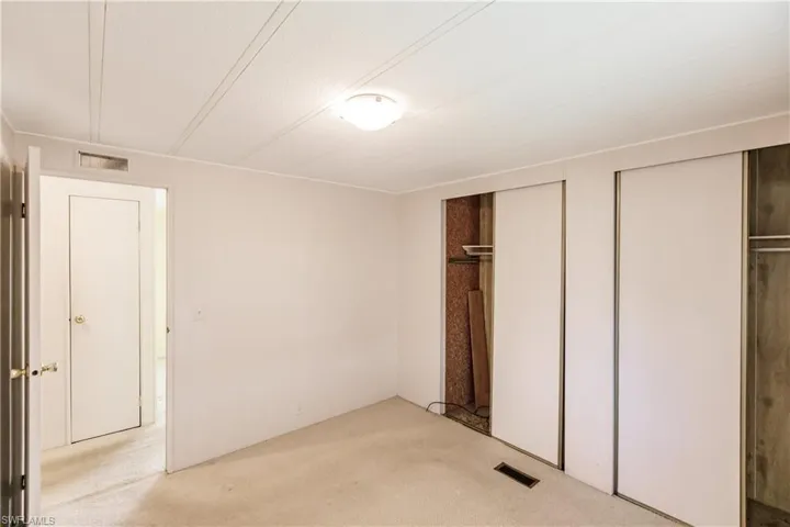 Unfurnished bedroom with multiple closets and light colored carpet
