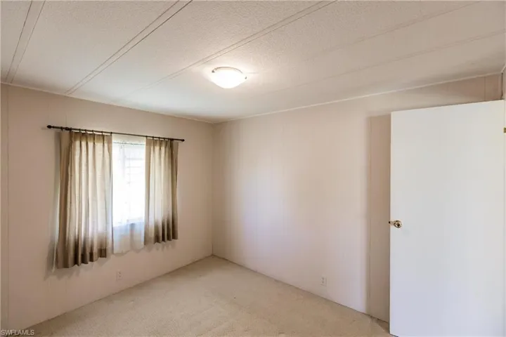 Unfurnished room with a textured ceiling and carpet flooring