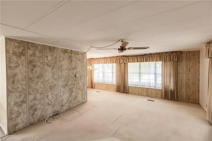 Empty room with ceiling fan and carpet floors