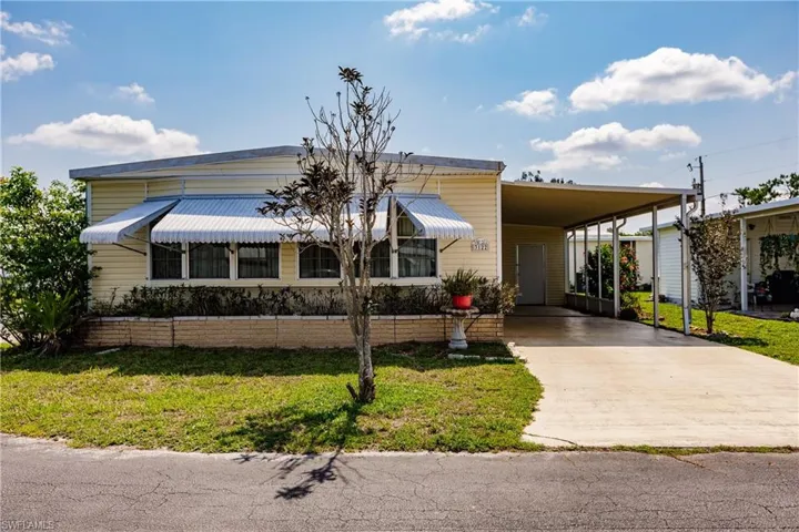 View of front facade with a front yard and a carport