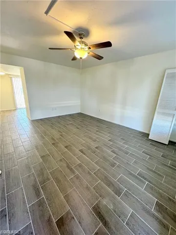 Wood-look tile flooring throughout, ceiling fan with integrated lighting, and white louvered bifold doors