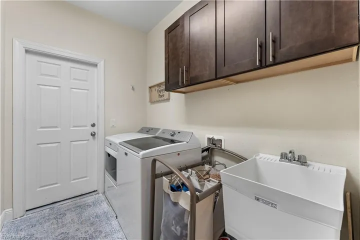 Washroom with washer and dryer, a sink, and cabinet space