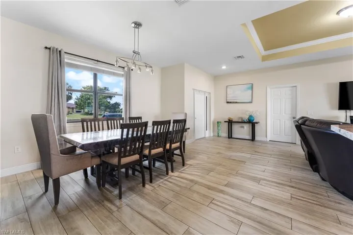 Dining area with a chandelier, light wood-type flooring, baseboards, and visible vents