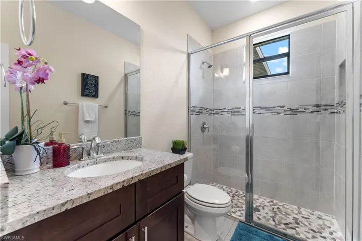 Full bath with a shower stall, vanity, and toilet