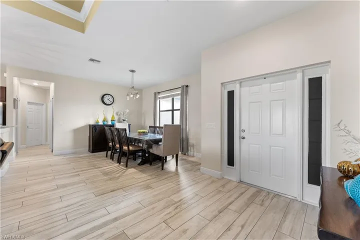 Dining space with light wood-style flooring, baseboards, and visible vents