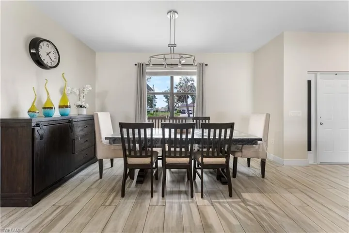 Dining space with a chandelier, light wood-style floors, and baseboards