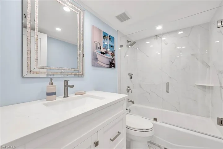 Bathroom featuring vanity, enclosed tub / shower combo, and recessed lighting