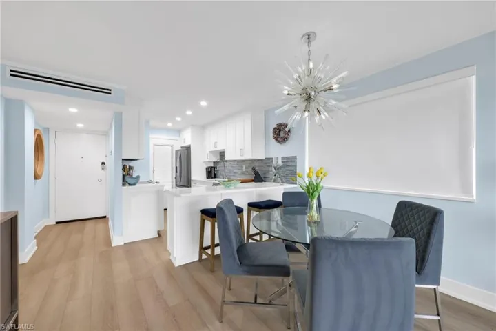 Dining space with a chandelier, light wood-type flooring, and recessed lighting