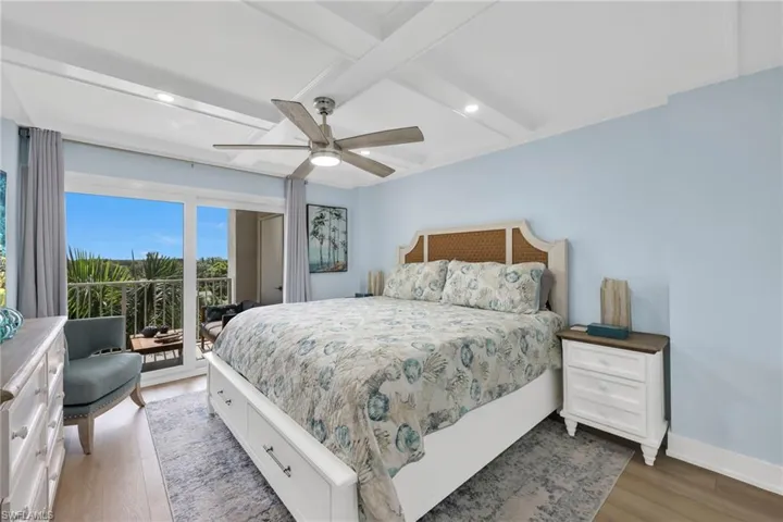 Bedroom featuring access to outside, coffered ceiling, wood finished floors, recessed lighting, and beamed ceiling