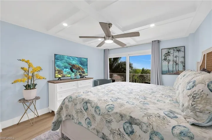 Bedroom with wood finished floors, access to outside, beam ceiling, recessed lighting, and coffered ceiling