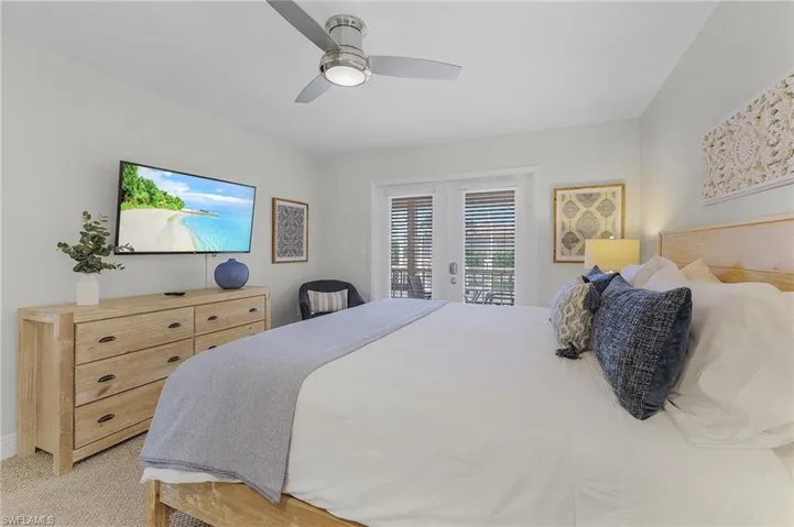Bedroom with light carpet, ceiling fan, access to exterior, and french doors