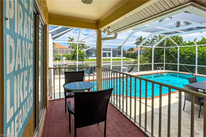 View of swimming pool with glass enclosure and a patio area