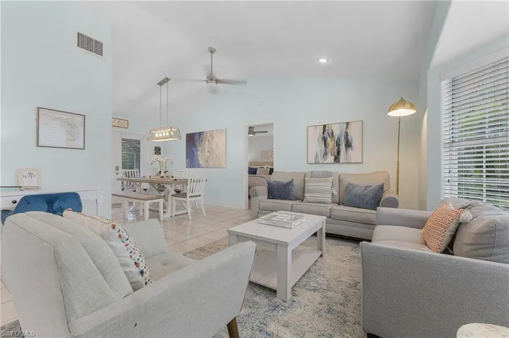 Tiled living room with high vaulted ceiling and ceiling fan