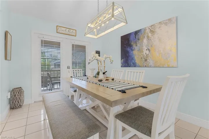 Tiled dining space featuring a notable chandelier