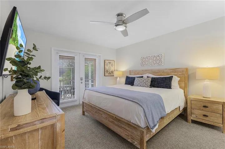 Bedroom featuring access to outside, light carpet, ceiling fan, and french doors