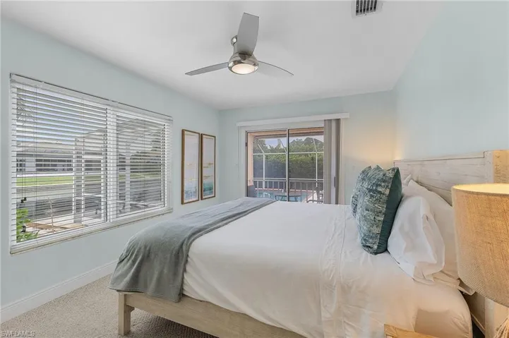 Carpeted bedroom with access to outside and ceiling fan