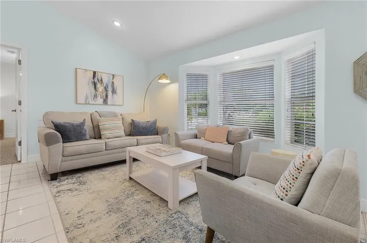 Tiled living room featuring vaulted ceiling